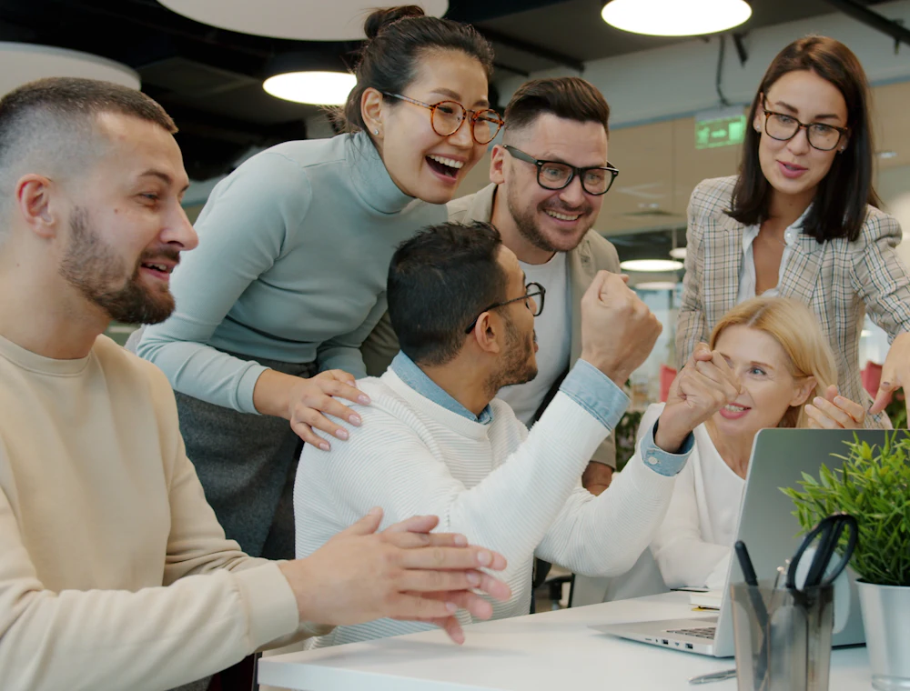 A team celebrating together at their desks